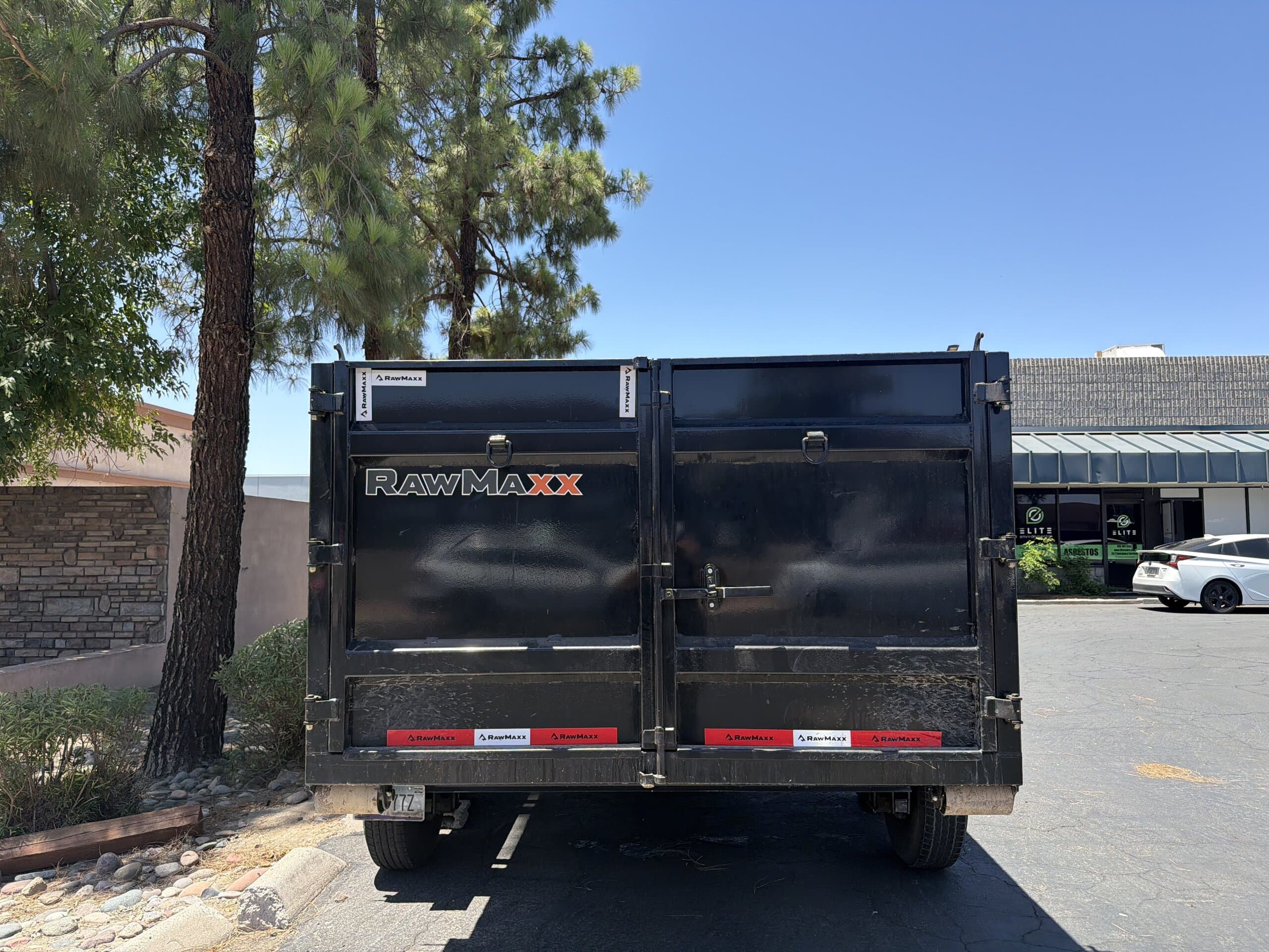 Rear door of a Toss It dump trailer ready for loading
