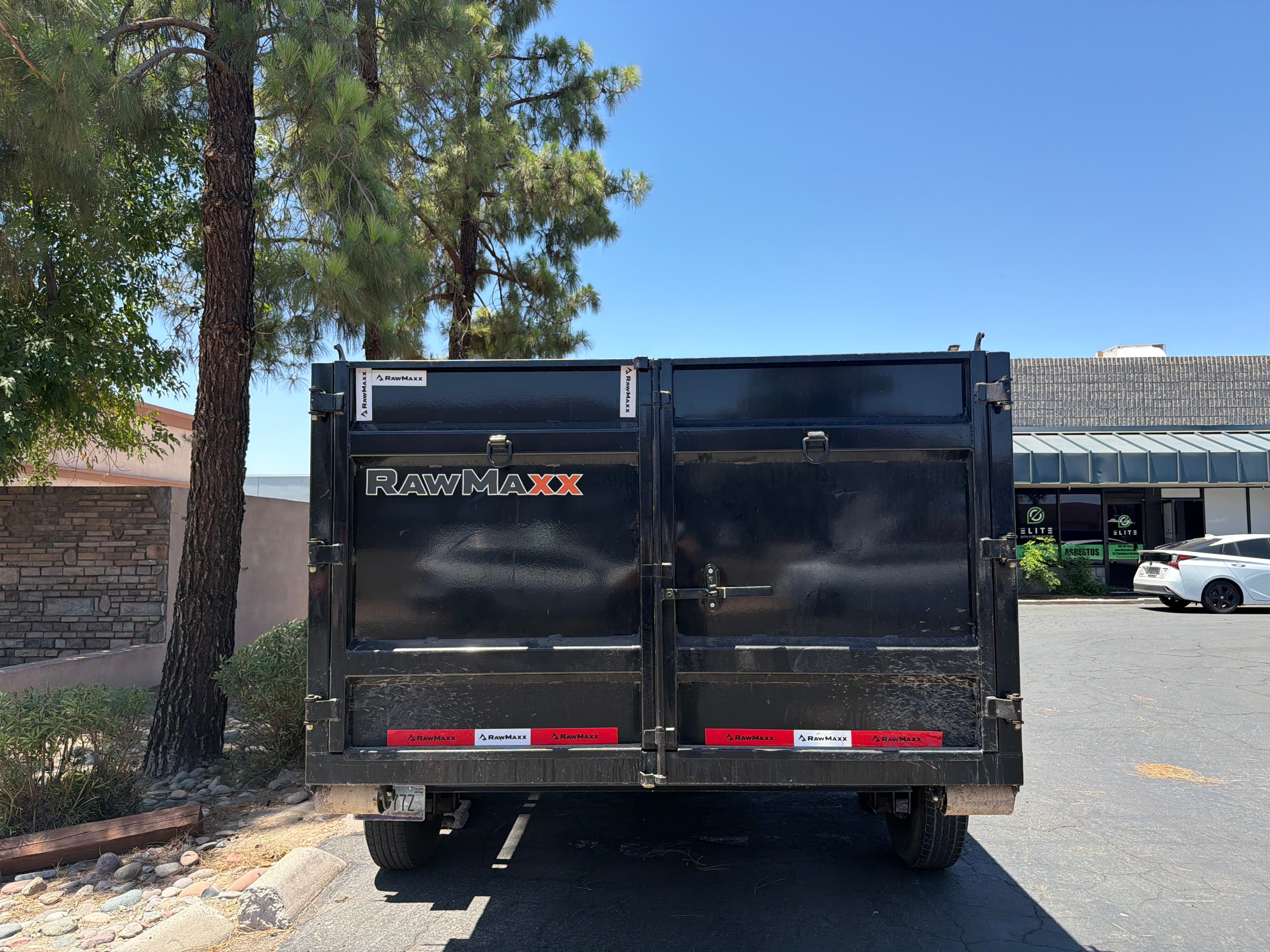 Rear door of a Toss It dump trailer ready for loading