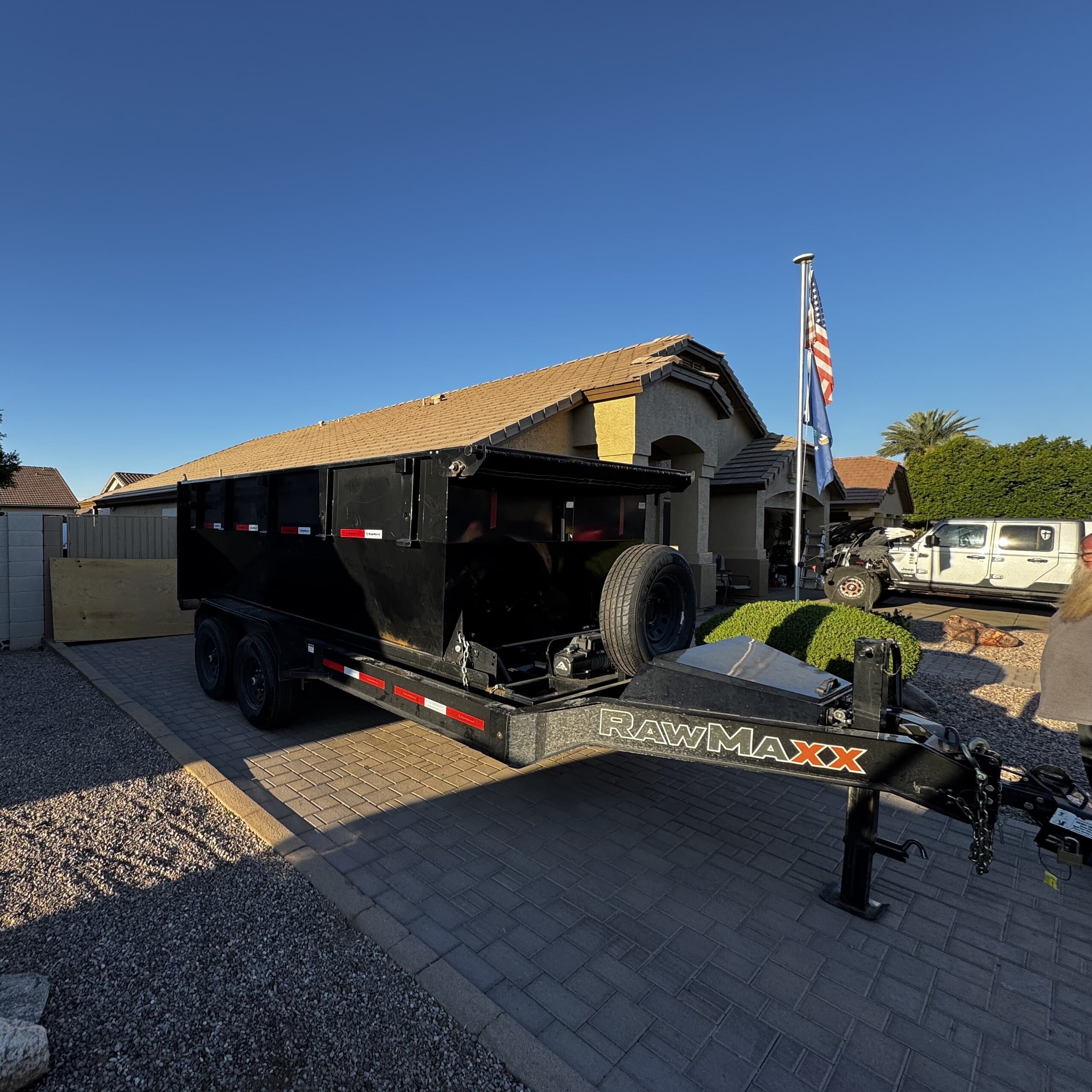 Toss It dump trailer parked in a residential driveway, ready to load