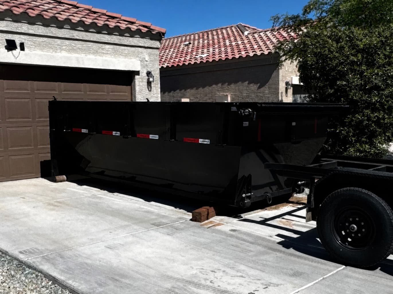 Toss It dumpster trailer staged in a residential driveway