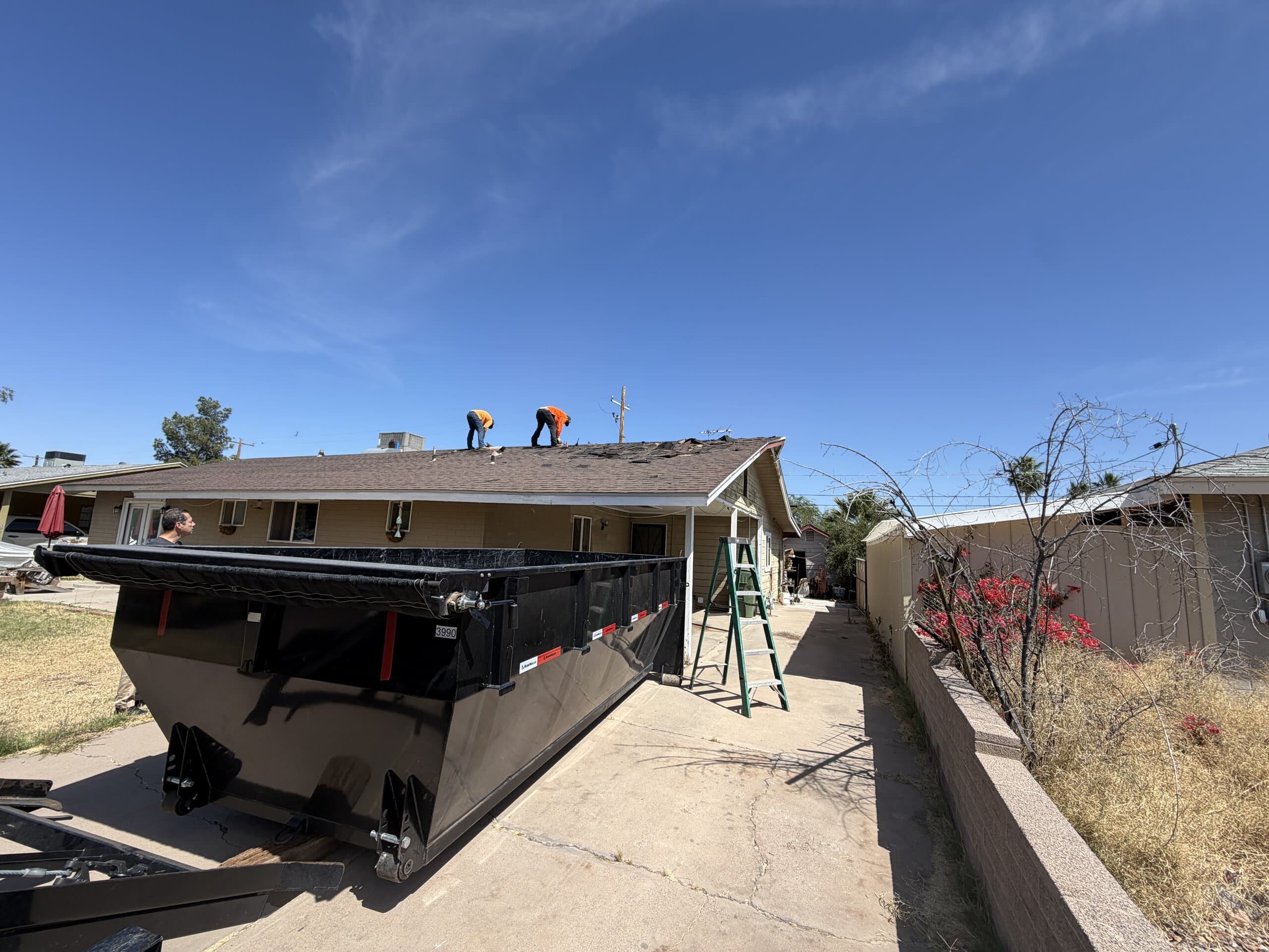 Toss It dumpster trailer positioned for a roofing debris cleanup