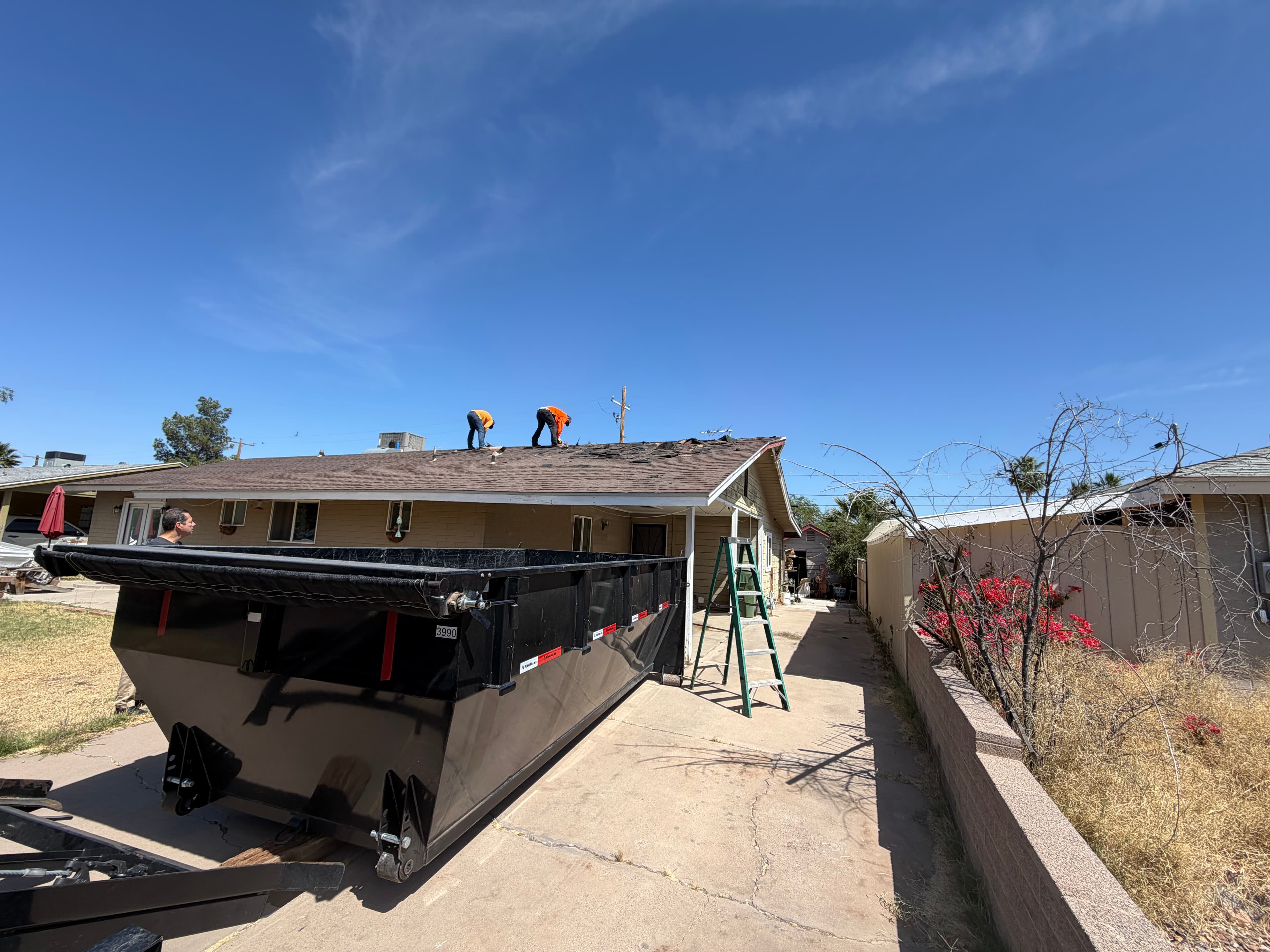Toss It dumpster trailer positioned for a roofing debris cleanup